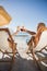 Couple clinking their glasses while relaxing on their deck chair