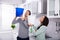 Couple Collecting Water Leaking From Ceiling In Bucket