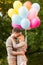 Couple with colorful balloons kissing in the park