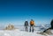 Couple connected team rope  with climbing harness dressed mountaineering clothes with backpacks and ice axes enjoying views