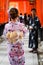 Couple in cotton yukata posing inside the vermillion torii gate tunnels at Fushimi Inari shrine, Kyoto