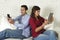 Couple on couch ignoring each other using mobile phone and digital tablet in internet addiction