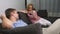 Couple crisis. Man and woman spend the evening in the living room on the couch. the woman uses the phone, the man is