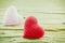 Couple of crochet heart in red and pink over wooden background.