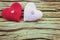 Couple of crochet heart in red and pink over wooden background.