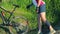 Couple crossing a stream together with their bikes in countryside