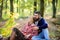 Couple cuddling drinking wine. Happy loving couple relaxing in park together. Romantic picnic with wine in forest