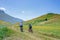 Couple cycling mtb in blooming cultivated fields, famous colourful flowering plain in the Apennines, Castelluccio di Norcia
