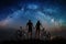 Couple cyclists with mountain bikes at night under starry sky