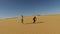 Couple dancing barefoot in desert, Egypt