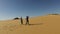 Couple dancing barefoot in desert, Egypt