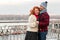 Couple dancing on the bridge. Smiling happy couple hugging near of barrier. Sweet people love daily walking in city.