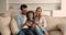 Couple and daughter relaxing on couch having fun using smartphone
