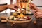 Couple with different types of delicious cheeses at table, closeup