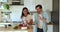 Couple distracted from food preparation dancing in domestic kitchen