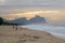 Couple and dog running on the beach of Barra da Tijuca in a beautiful dawn with the stone of Gavea in the background - Rio de Jane