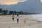 Couple and dog running on the beach of Barra da Tijuca in a beautiful dawn with the stone of Gavea in the background - Rio de Jane