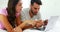 Couple doing online shopping on laptop in bedroom