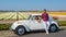 couple doing a road trip with an old vintage car in the Dutch flower bulb region with tulip fields