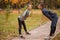 A couple are doing sports in the park in the fall. Do the slopes. Outside.