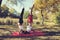 Couple doing yoga in autumn city park Pregnant woman Upside down