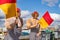 A couple dressed as novelty lifeguards waving flags at the annual maritime festival