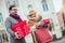 Couple dressed in winter clothing holding gift boxes outdoor