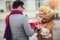 Couple dressed in winter clothing holding gift boxes outdoor