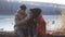 Couple drinking hot tea while relaxing by frozen lake