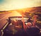 Couple Driving Convertable at Sunset