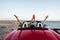 Couple driving convertible car near the ocean