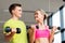 Couple with dumbbells exercising in gym