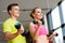 Couple with dumbbells exercising in gym