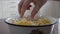 Couple eating sauerkraut with hands from metal bowl.