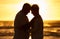 Couple, elderly and silhouette at beach with hug in sunset, evening or dusk by water, waves or horizon together. Senior