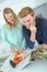 Couple embracing in kitchen while checking recipe book