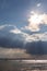 A couple of empty, little sailboat on a lake, beneath a moody sky with sun rays filtering through