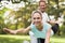 A couple is engaged in sports in a warm summer park. A man helps a woman stretch.