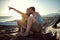 Couple enjoying at beach, sitting together with legs intertwined, watching something far away