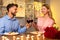 Couple enjoying candlelit dinner with wine and roses