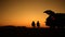 Couple Enjoying Scenic Sunset on a California Desert Seating Next to Their Vehicle