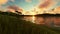 Couple enjoying a sunset, beautiful green meadow and lake surrounded by mountains