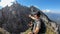 Couple enjoying the view on sharp and steep Alpine slopes in the region of Grimming. The slopes are full of lose stones.