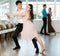 Couple in evening dresses enjoys pair dance tango, interacting with each other on floor