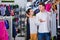 Couple examining various sports clothes in sports store