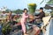 A couple of farmers transport flowers on the riverbank to serve