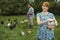 Couple Feeding Hens On Grassland