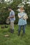 Couple Feeding Hens On Grassland