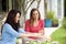 Couple of female friends sitting outdoors eating lunch