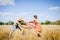 Couple fighting in field hoding suitcase on countryside landscape blue sky background outdoors